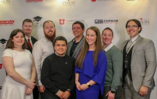 West High board members and scholarship recipients stand in front of a banner at the 2019 Union Scholarship Celebration.